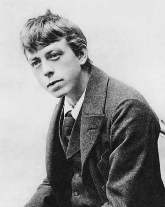Black-and-white photograph of a young man wearing a coat and tie