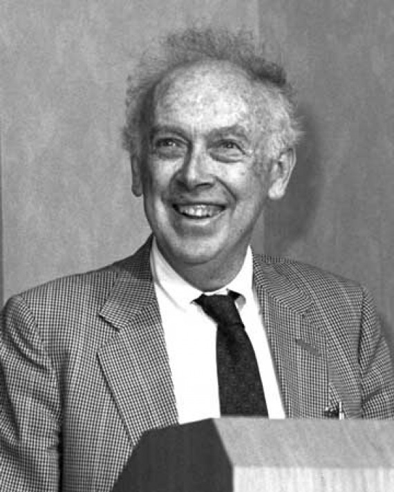 Smiling man with thin hair sticking out at a podium