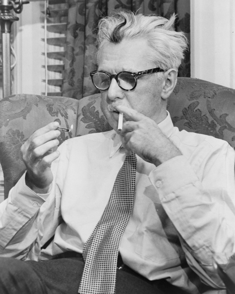 black and white photo of James Thurber lighting a cigarette in the new york times office