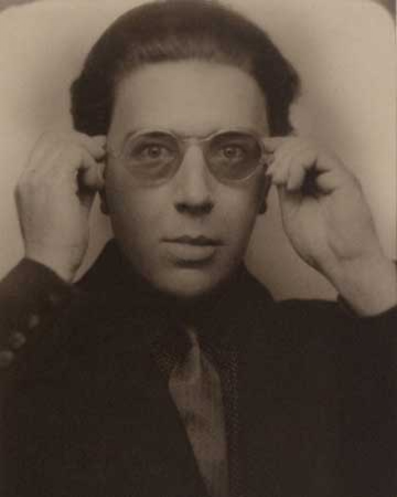 Photograph of a man holding tinted glasses to his face