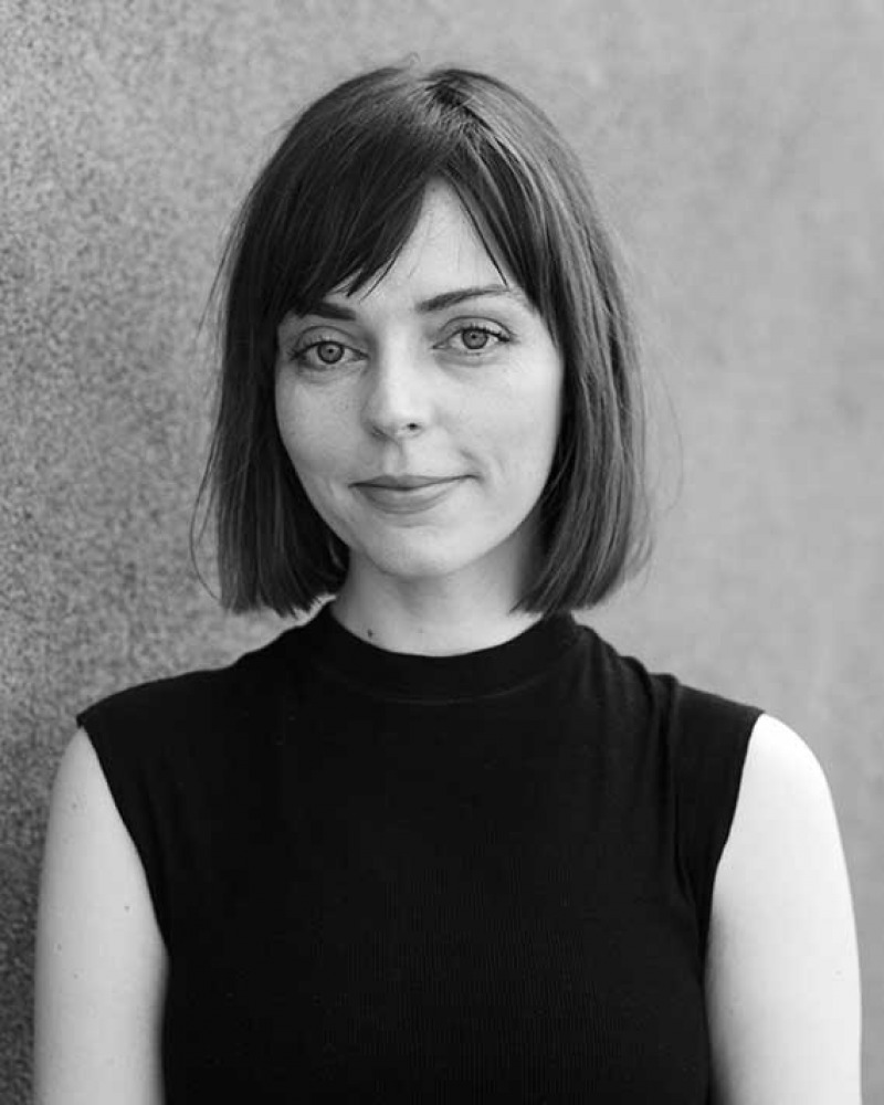 Black and white photograph of a woman with chin-length dark hair wearing a sleeveless turtleneck