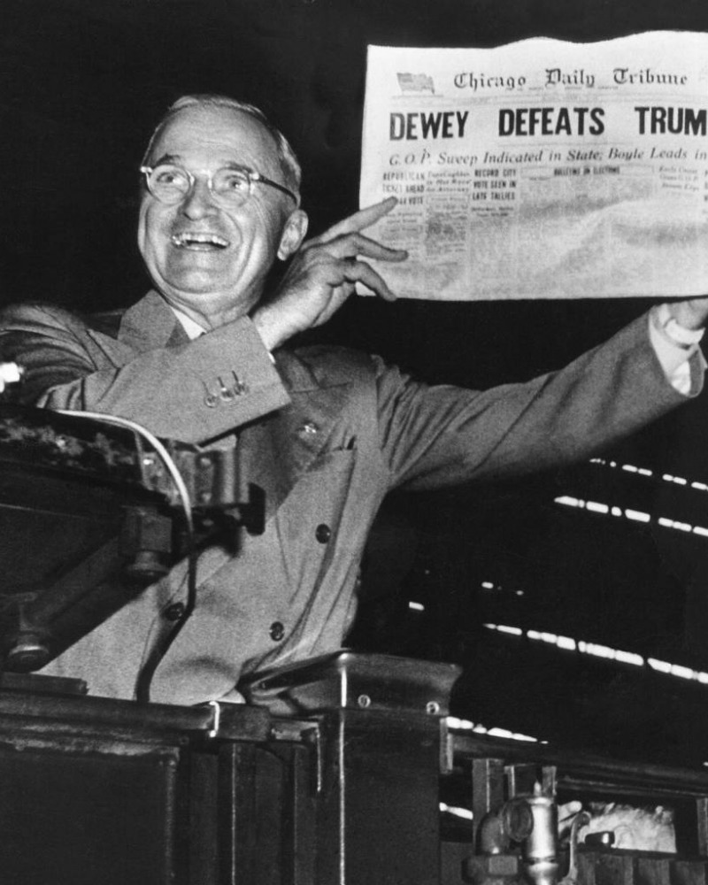 Black and white photo of Harry S. Truman holding a newspaper with the headline "Dewey defeats Truman"