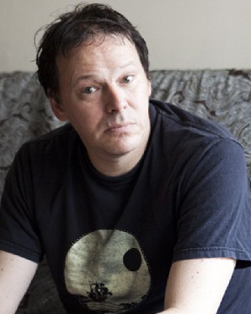Color photograph of author David Graeber wearing a t-shirt.