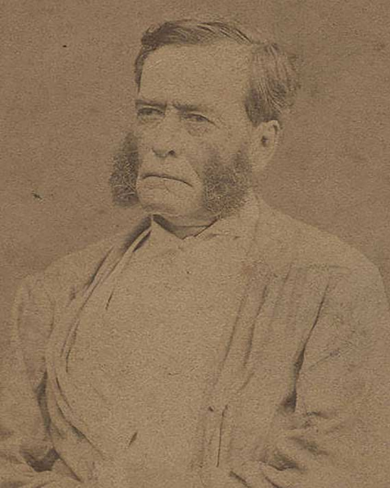 Sepia image of a stern-looking older man with heavy side whiskers
