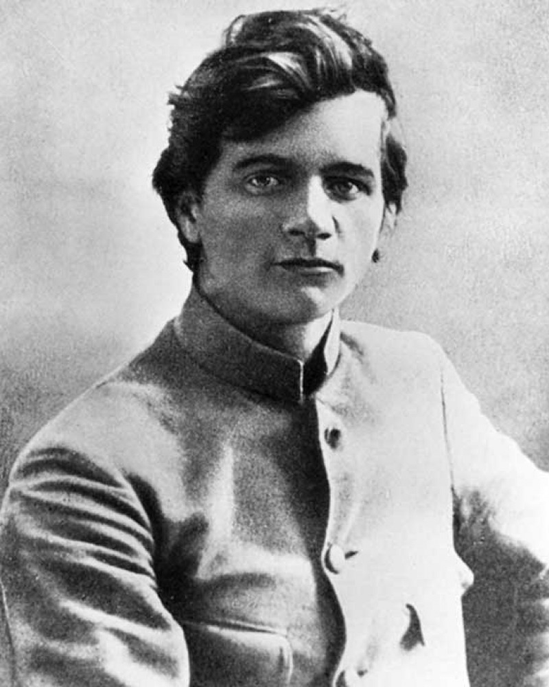 Young man in collarless jacket seated