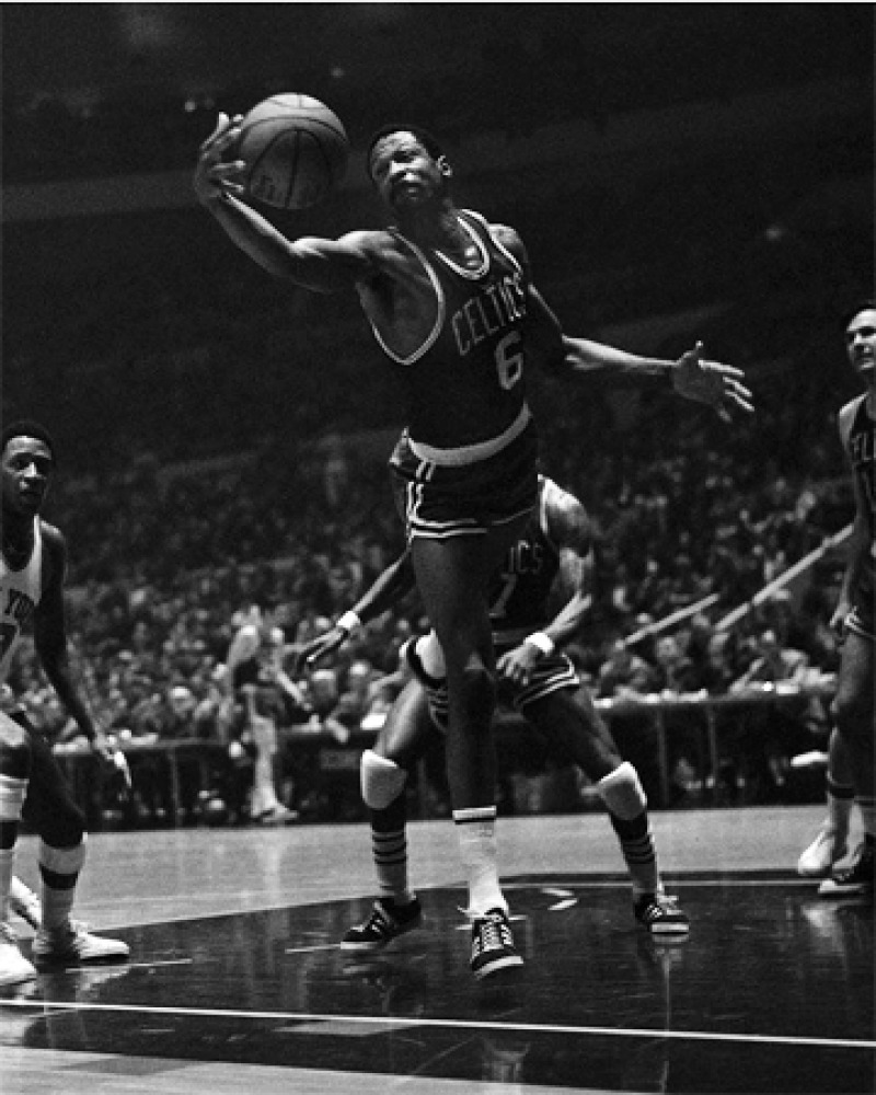 Bill Russell leaps for a basketball while playing for the Celtics.