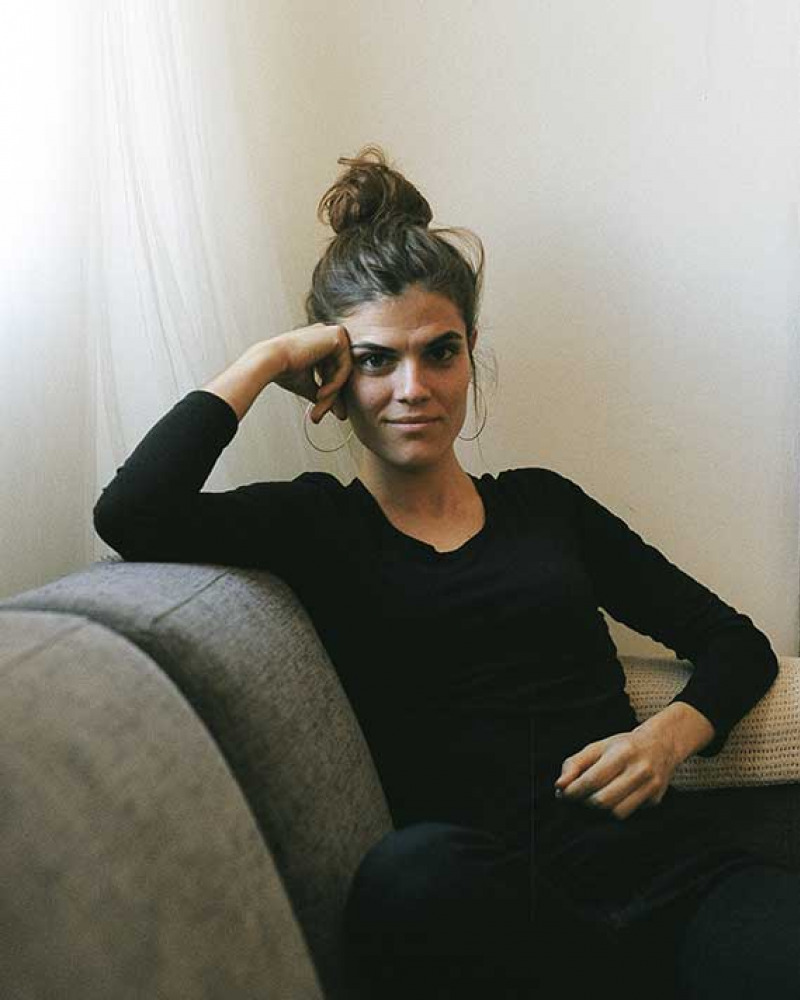 Young woman wearing black seated on a couch