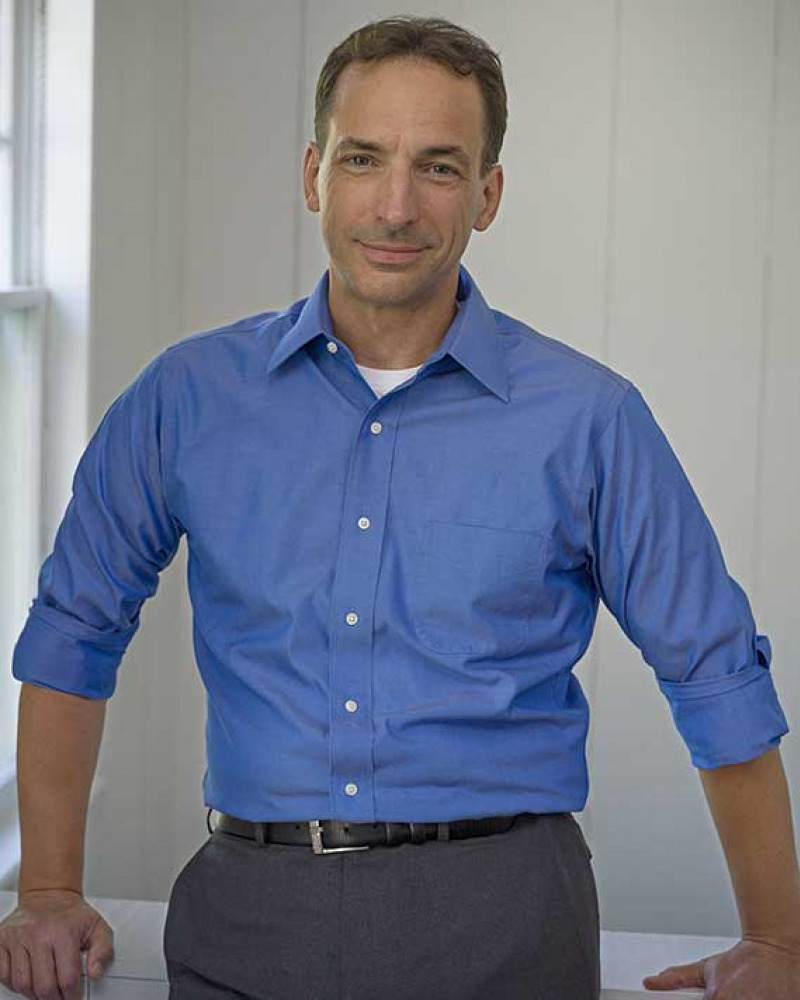 Smiling man in blue shirt and gray pants