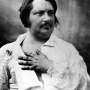 Image of French writer Honoré de Balzac with hand on chest.