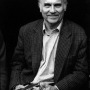 Black and white photograph of Ryszard Kapuściński holding a book.