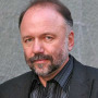 Man with a graying beard wearing a dark suit jacket
