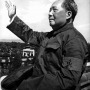 Black and white photograph of Mao Zedong with raised arm.