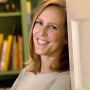 Color photograph of American writer Mary Roach leaning on door.