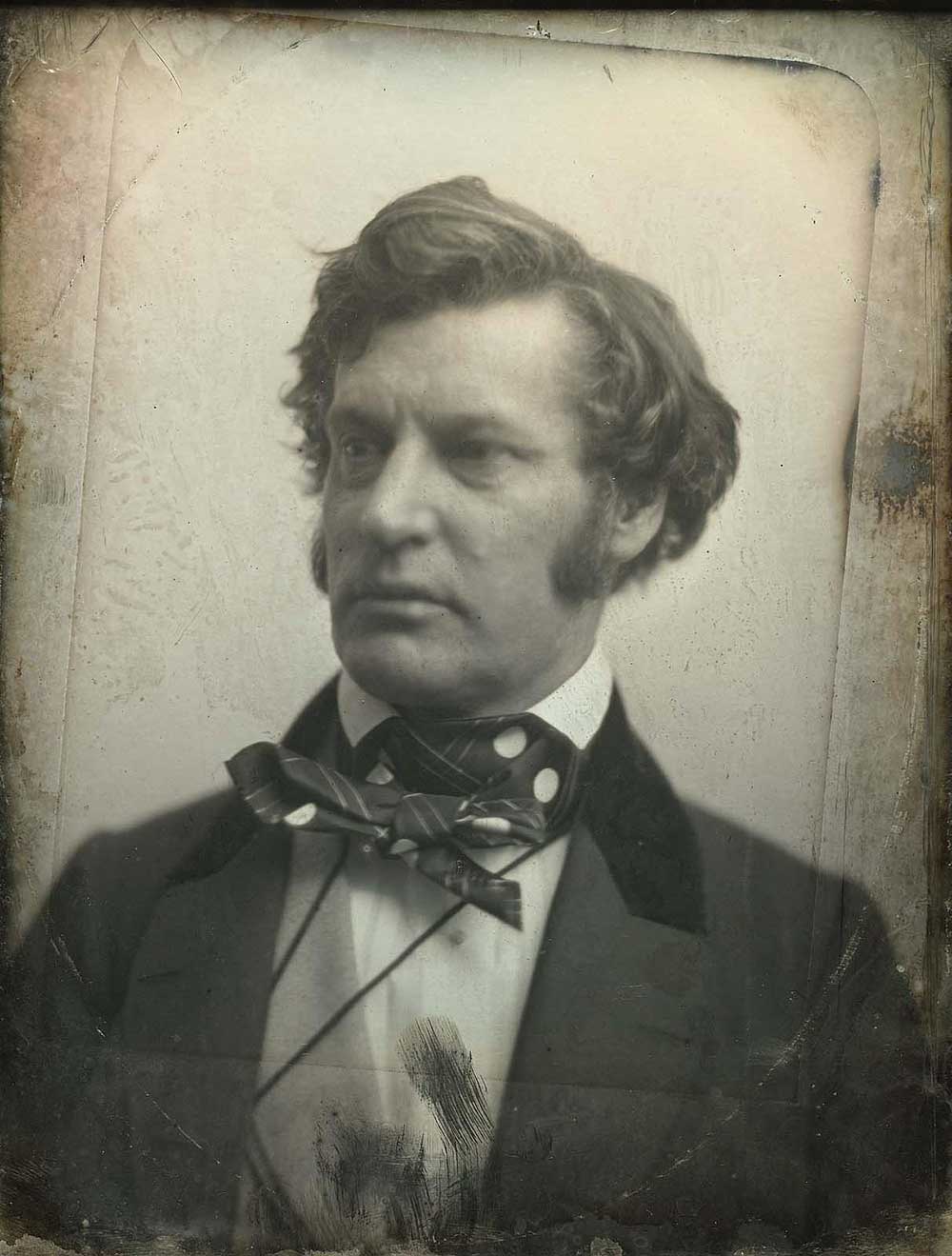 Black-and-white profile of a man with sideburns looking to his right