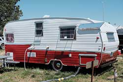 Old-fashioned white and red trailer on grass