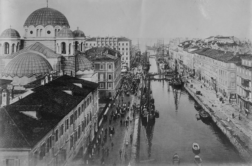 Black and white photograph of a canal lined with buildings.