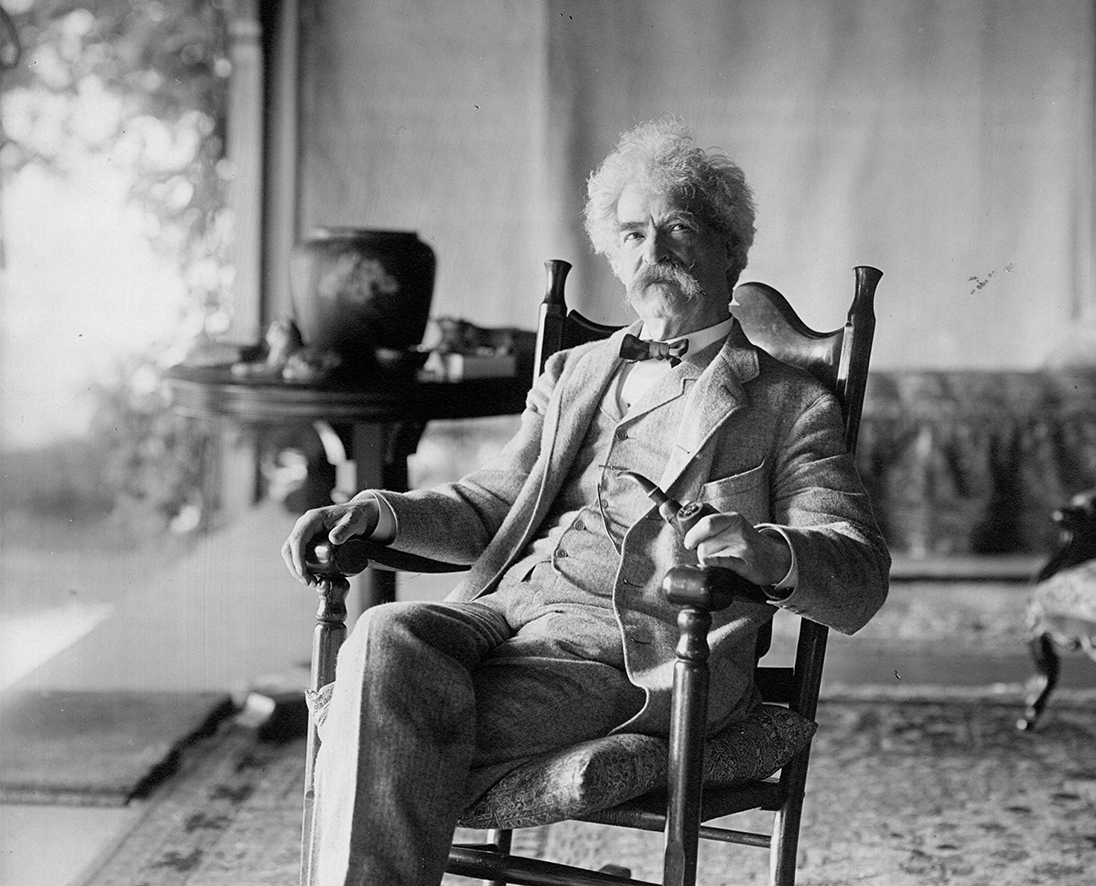 Mark Twain seated in a rocking chair on the porch. The Center for Mark Twain Studies, Elmira College.