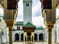 Building at the end of a courtyard seen through an ornate archway